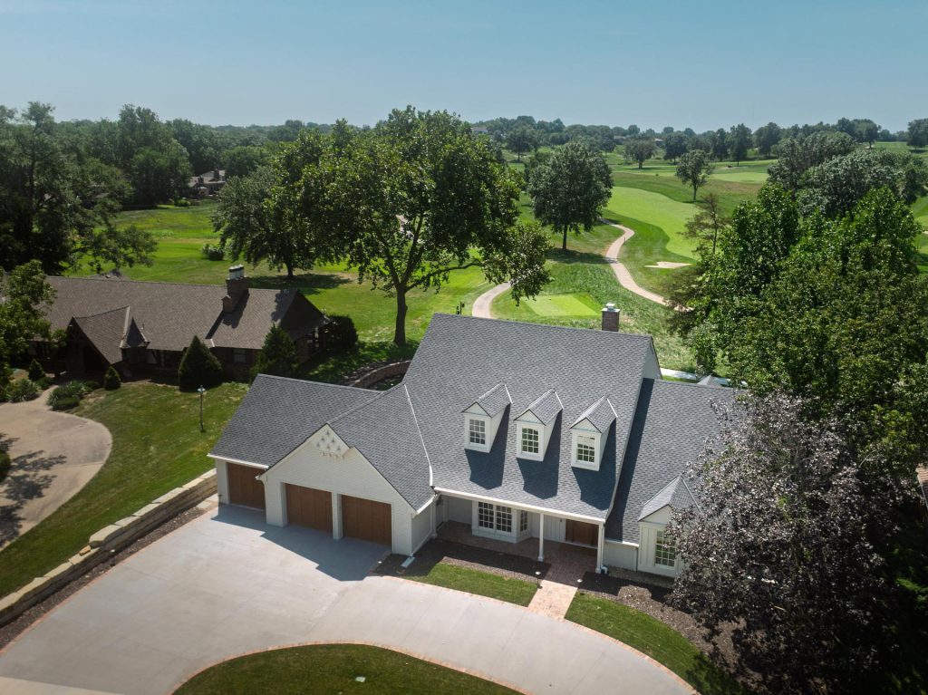 Aerial view of a remodeled two-story home near a golf course in Lawrence, Kansas
