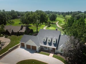 Aerial view of a remodeled two-story home near a golf course in Lawrence, Kansas