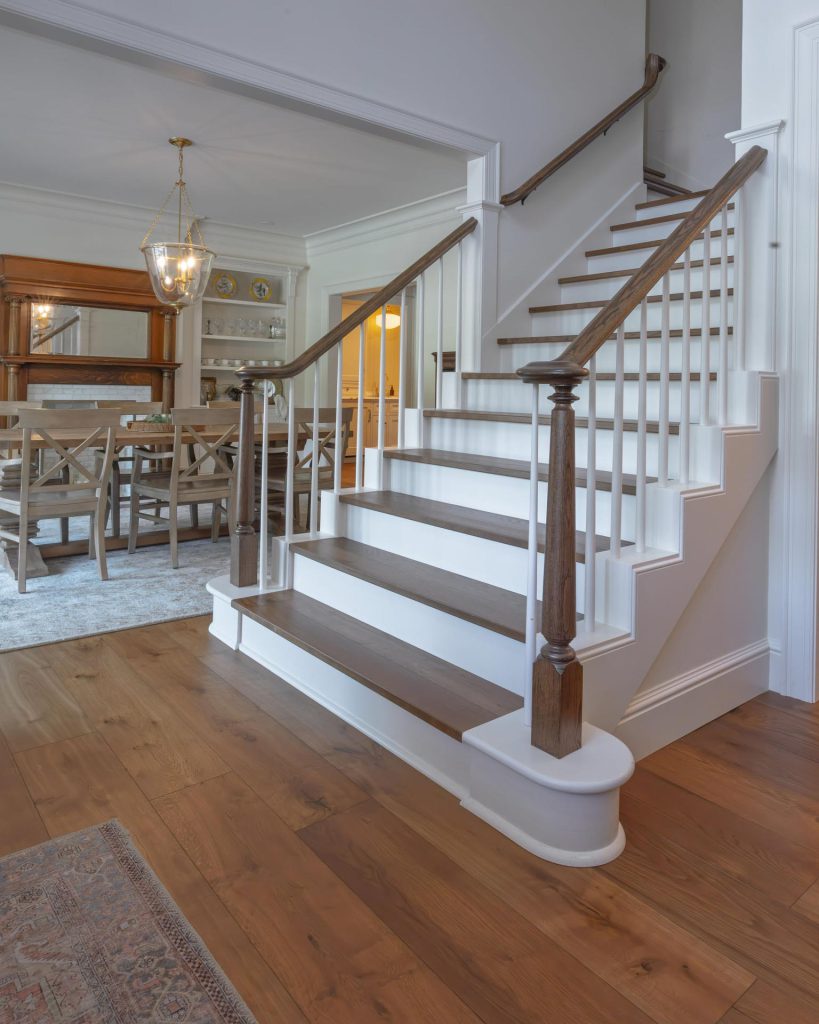 Wood staircase overlooking an open dining room after a whole-home remodel in Lawrence, Kansas
