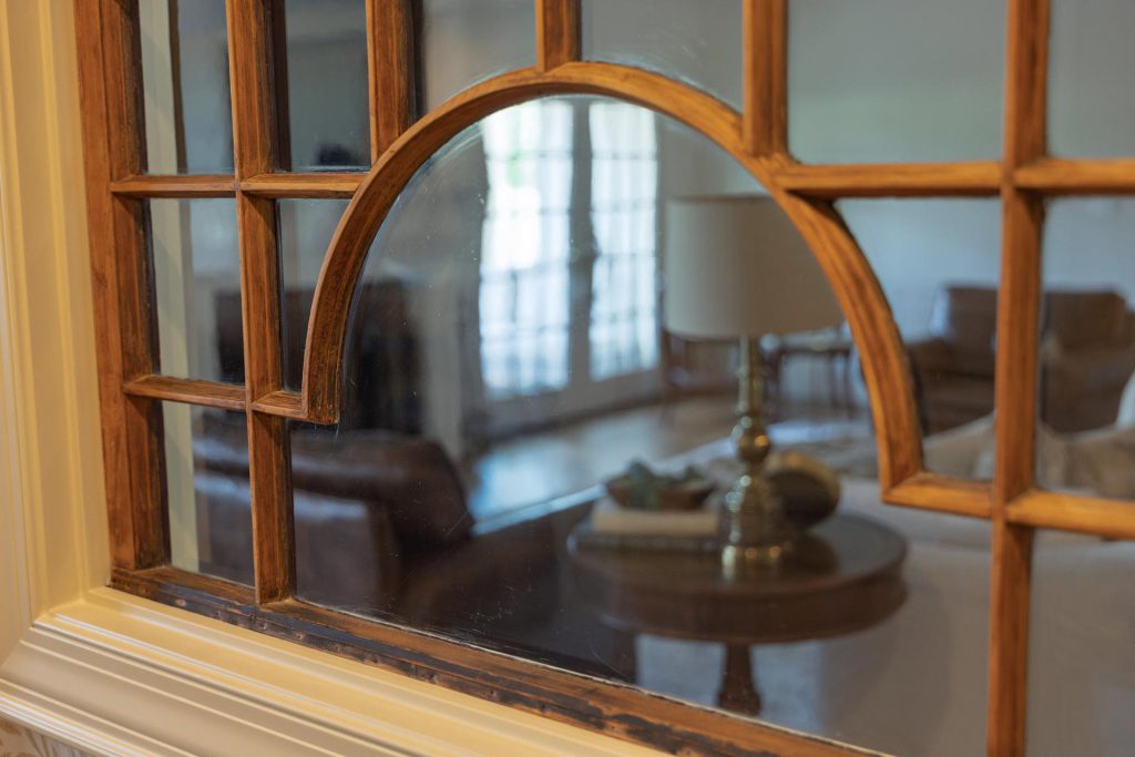 A 100-year-old wooden window repurposed as an interior opening between the living room and wet bar