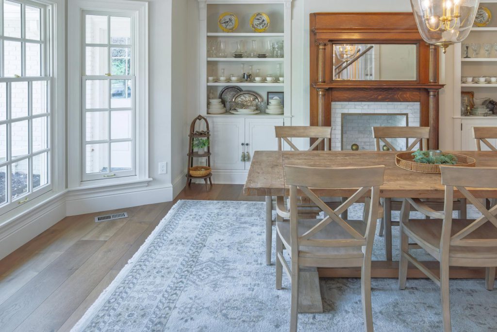 Antique fireplace surround framed by refinished historic cabinets in a Lawrence dining room remodel