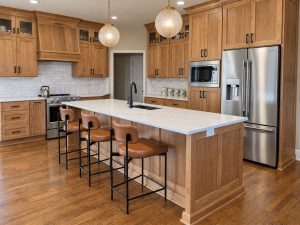 Remodeled kitchen with wood cabinetry, quartzite island, and stainless appliances in a Kansas City home